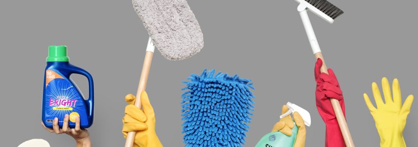 Hands holding cleaning tools and solutions